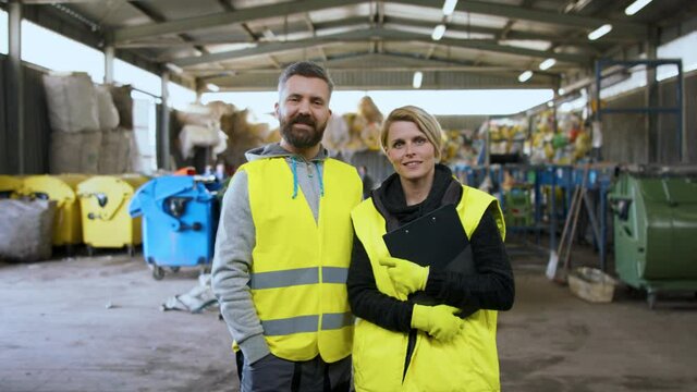 Man and woman workers on landfill, waste management and environmental concept.