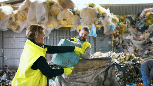 Man and woman workers on landfill, waste management and environmental concept.