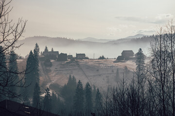 Häuser auf dem Berg... Ein kleines Dorf in den Karpaten in der Ukraine auf einem Berg im Morgengrauen im Winter bei Hintergrundbeleuchtung...