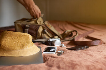 The idea of ​​traveling with a hat and bag and a laptop, then a man's hand picked from the bag.