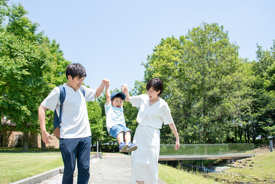 手を繋いで歩く家族
