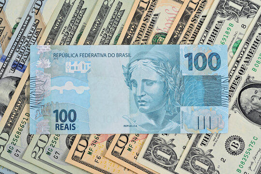 Nota de 100 reais junto com d&oacute;lares americanos de diversos valores