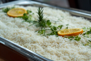 Untouched freshly cooked rice with some oranges on top.