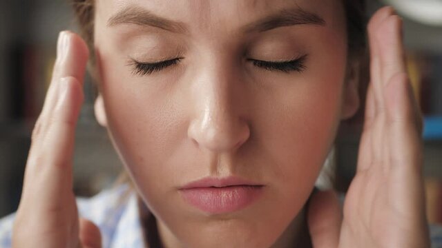 Headache. Close-up face woman her hands touches forehead and temporal region, experiences pain in head. Hypertension, fatigue, stress concept