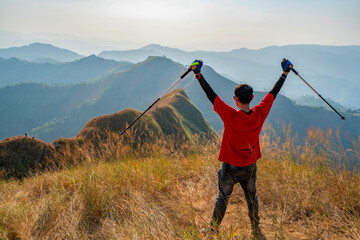Fototapeta na wymiar traveler man hiking enjoying in the mountains with backpack at Khao Chang Puak mountain Thailand