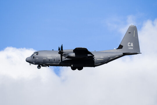 May 14, 2020 Mountain View / CA / USA - Side view of US Air Force military aircraft performing a training flight; blue sky with white clouds background
