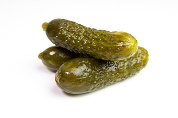 Pickled cucumbers or gherkins in a pile isolated on white.