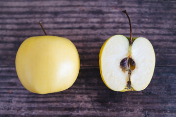 plant-based food, apple halves on wooden table next to whole apple