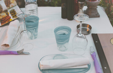 Traditional blue and white greek tavern with tables served and prepared for lunch of tourists in the summer season. 