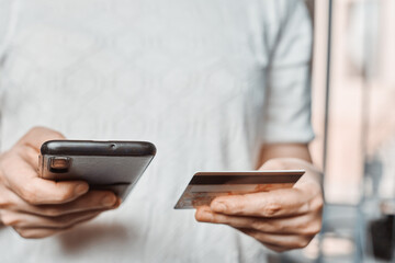 Online shopping concept. Young woman filling and paying order in online store application. Close-up view of unrecognizable female purchasing clothes online