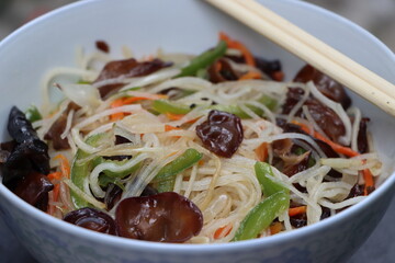 Rice noodles stir fry in bowl with ear wood mushrooms, vegetables