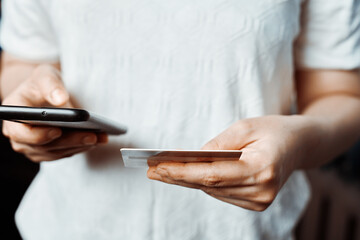 Online shopping concept. Young woman filling and paying order in online store application. Close-up view of unrecognizable female ordering food