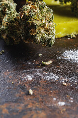 rustic cannabis butter and medical marijuana bud and flour on old rust metal dripping pan. old wooden background. vertical. close-up.
