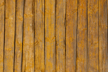 Texture of a yellow fence made of wooden boards