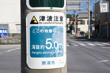 katsuura, chiba, japan, 09/01/2019 , Be careful of tsunami sign, attached in every pole of the city telling also how high on the sea level it is.