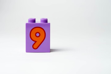 the number nine written on the block from the children's constructor