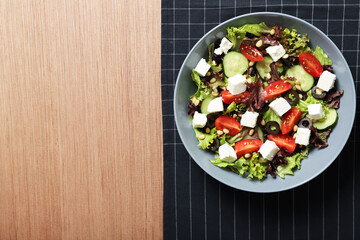 Plate with tasty greek salad on the table. Place for text