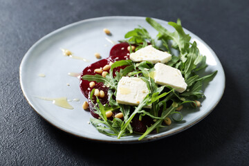 Tasty salad with beetroot and feta. On a black background