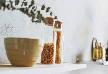 Glass jars with dry pasta in the kitchen, zero waste concept