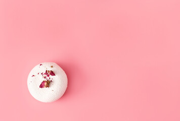 One mousse pastry dessert covered with white chocolate and decorated with rose buds on pastel pink background. Modern stylish cake. Flat lay style. Copy space. Close-up.