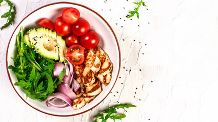 Fresh vegetables salad from grilled Halloumi cheese, tomatoes, avocado, arugula in craft plate. Top view