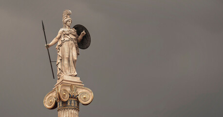 Athena goddess marble statue with spear and shield isolated on dark grey sky background, lots of...