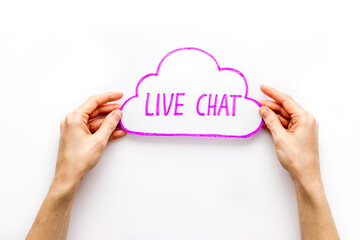 Live chat concept - bubble in hands on white desk top view