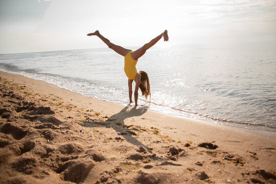 Active girl have fun in the beach and doing cartwheel on sea beach on summer time. - Powered by Adobe