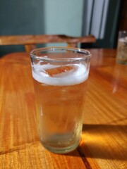 A glass of beer placed on a wooden table
