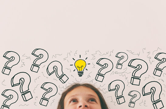 education concept with young girl looking up with light bulb and question marks. Concept of idea and creative thinking