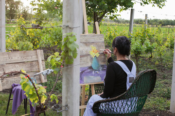Girl painting on an easel surrounded by nature
