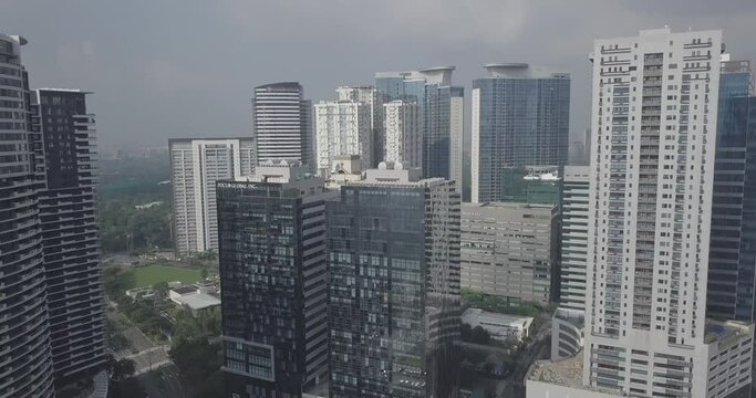Ungraded, Ascending aerial flight over business district area. Tilt down to reveal avenue's traffic line. Drone, 4K. 