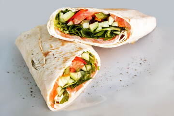 Shawarma sandwich - fresh roll of thin lavash or pita bread filled with grilled meat, mushrooms, cabbage, carrots