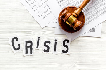 Debt in crisis - judge hammer - on white wooden desk top-down