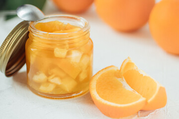 Naklejka na ściany i meble orange jam on a white background .glass jar of orange jam with fresh fruit