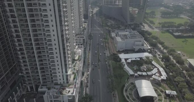 Ungraded, Forward aerial flight alongside skyscrapers following main avenue line. Business district area. Drone, 4K. 