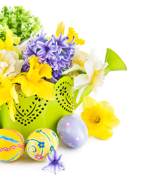 Easter eggs with spring flowers in watering can. Isolated on white background.