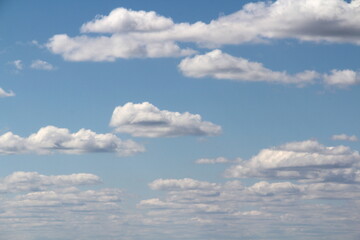 White fluffy clouds on a background of blue sky in summer. The concept of weather and climate.