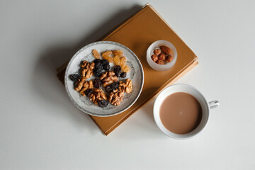 healthy breakfast of cocoa, nuts and raisins combined with reading a book.
lmage with selective focus