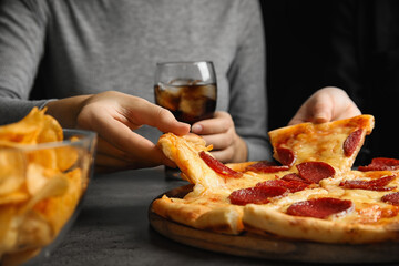 Women taking tasty pepperoni pizza at grey table, closeup