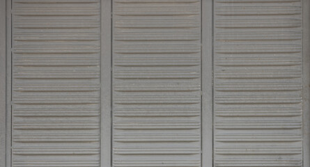 Old gray external metal closed shutter. Vintage style. Architecture facade design. Closeup.