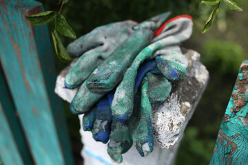 Working fabric gloves stained with green paint and a small knife for painting work.