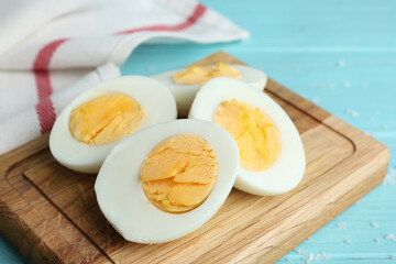 Cut hard boiled chicken eggs on wooden board