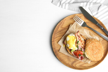 Delicious egg Benedict served on white wooden table, flat lay. Space for text