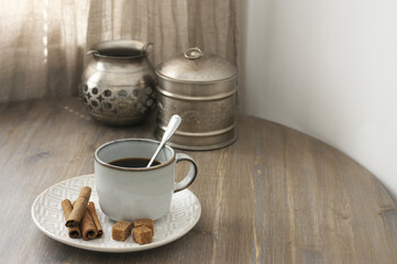 Coffee with cinnamon and silver utensils