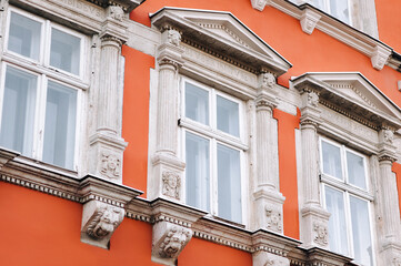 Windows on the red facade of the house in the central historical part of the city, view from below....