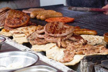 Traditional serbian street food (rostilj) - pljeskavica, cevapi, grilled chicken breast, bbq chicken wings and homemade sausages served with fresh bakery (lepinja)