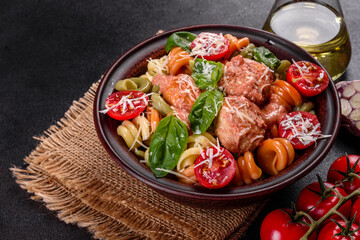 Delicious fresh pasta with meatballs, sauce, cherry tomatoes and basil