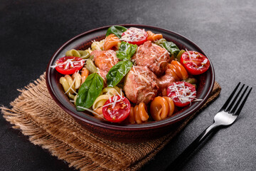 Delicious fresh pasta with meatballs, sauce, cherry tomatoes and basil