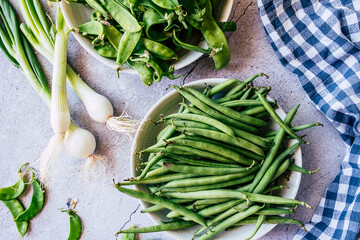 Haricots verts frais et oignons grelot sur la table de cuisine